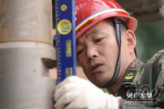 该部打井队技师、二级军士长范国书细心检测钻杆垂直角度