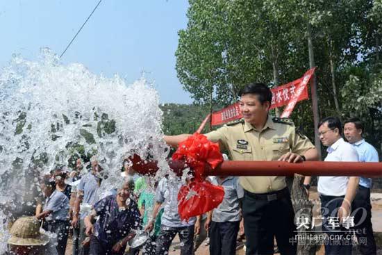 部队领导和群众一起为“扶贫井”出水竣工欢呼